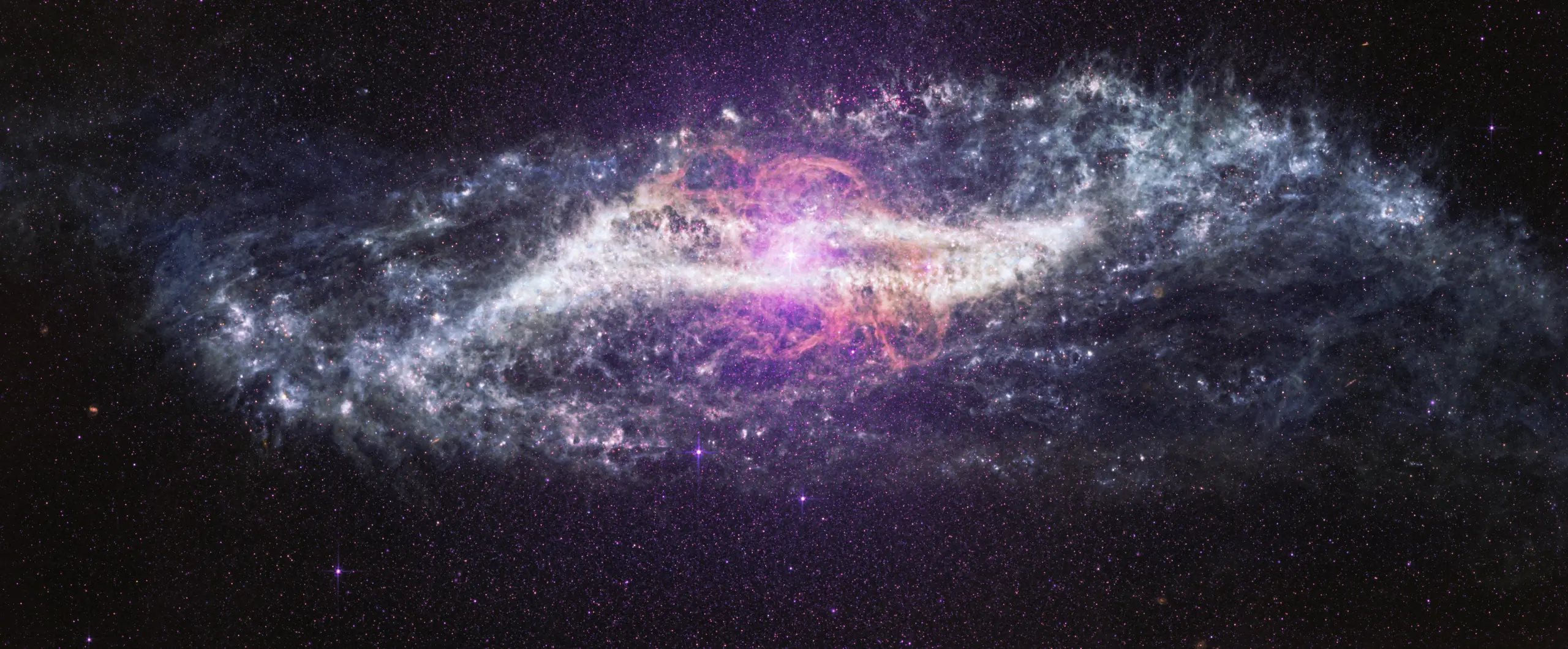 A galaxy crossed by a thick dark dust lane, its core glowing in infrared.